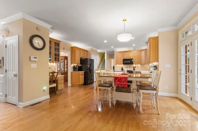a view of a dining room with furniture a kitchen and chandelier