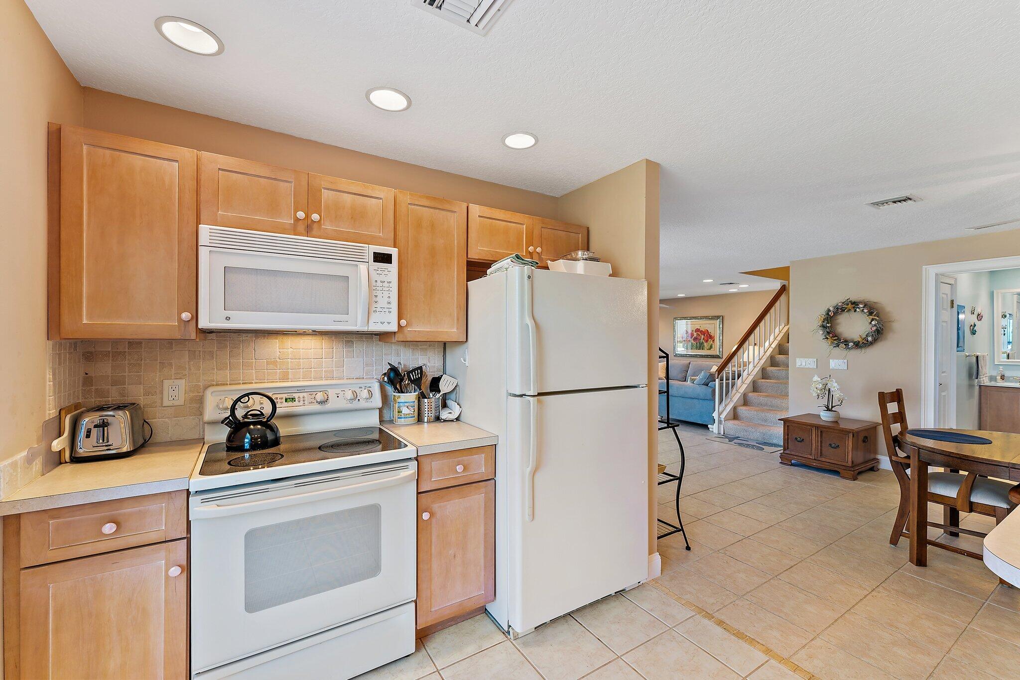 717 Highway 1, Unit 812 Jupiter, FL 33477 - Photo 9 of 41 a kitchen with appliances a refrigerator and cabinets