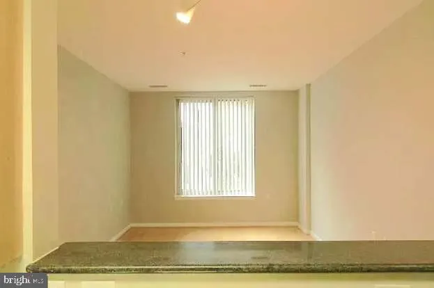 a view of a room with wooden floor and a window