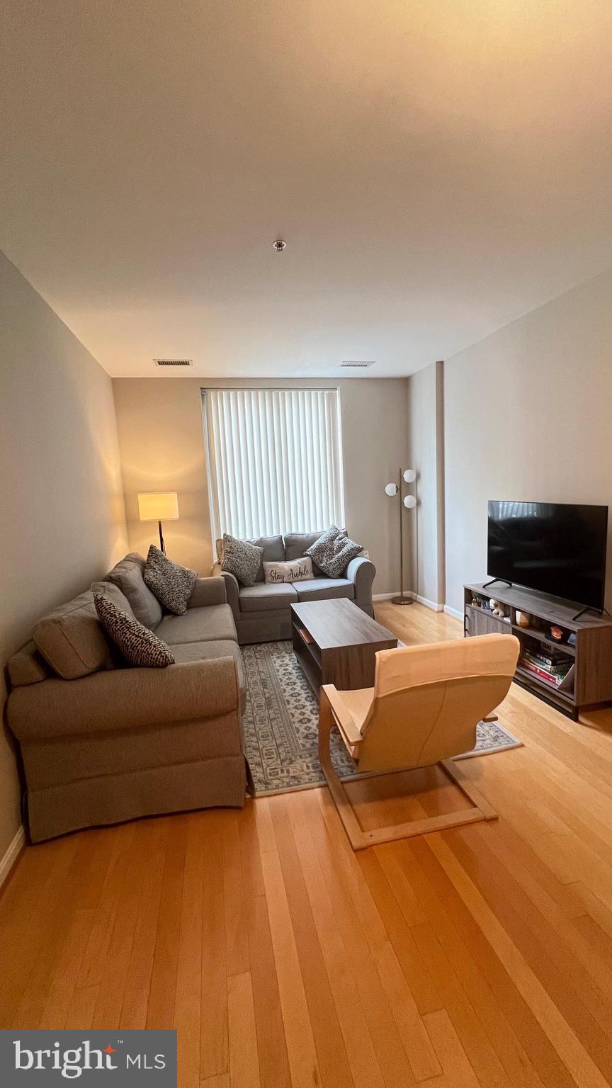 2726 Gallows Road, Unit 110 Vienna, VA 22180 - Photo 2 of 46 a living room with furniture and a flat screen tv
