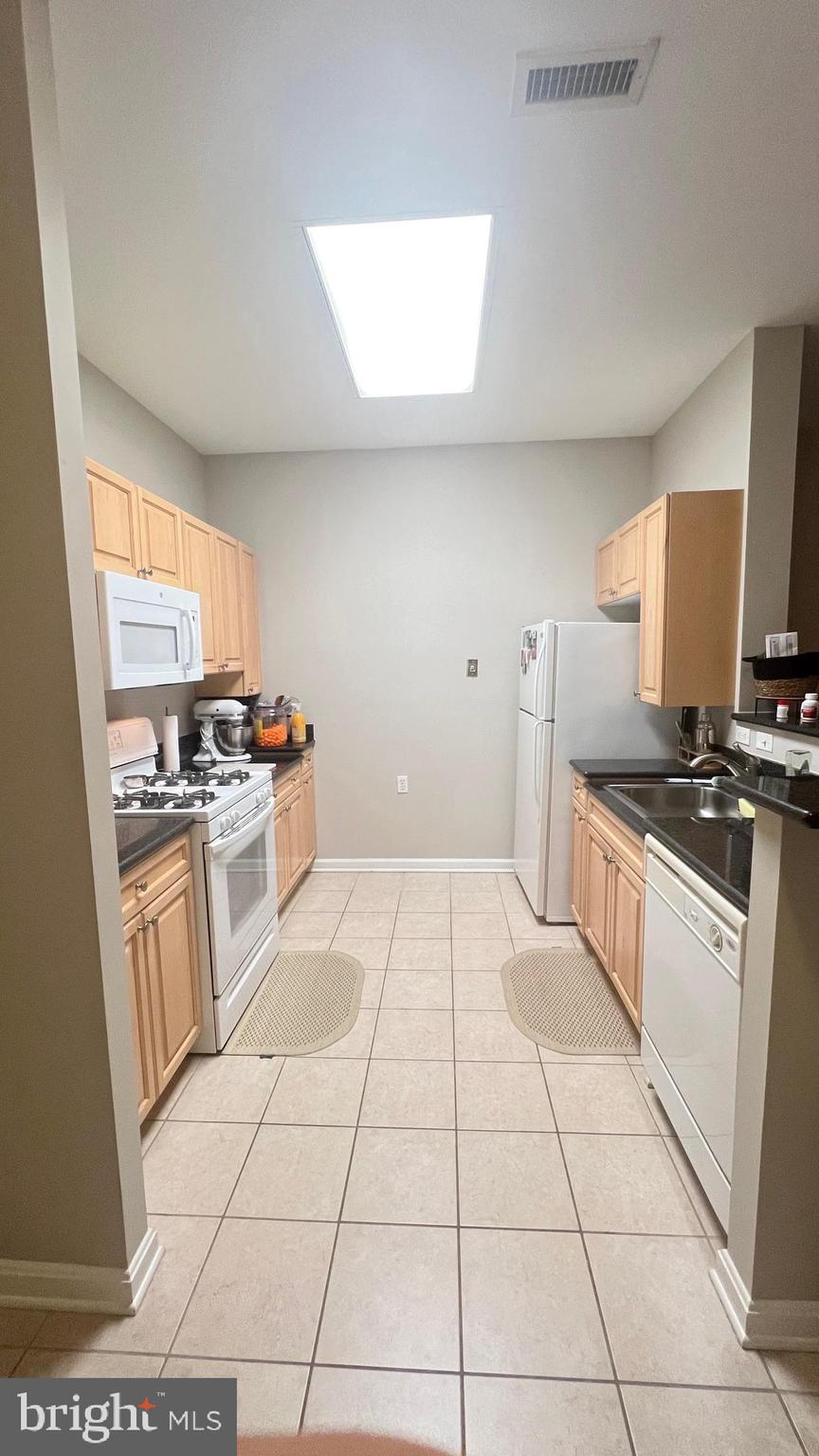 2726 Gallows Road, Unit 110 Vienna, VA 22180 - Photo 5 of 46 a kitchen with a stove a sink and a refrigerator
