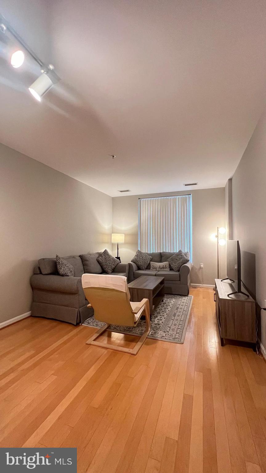 2726 Gallows Road, Unit 110 Vienna, VA 22180 - Photo 7 of 46 a living room with furniture and a lamp