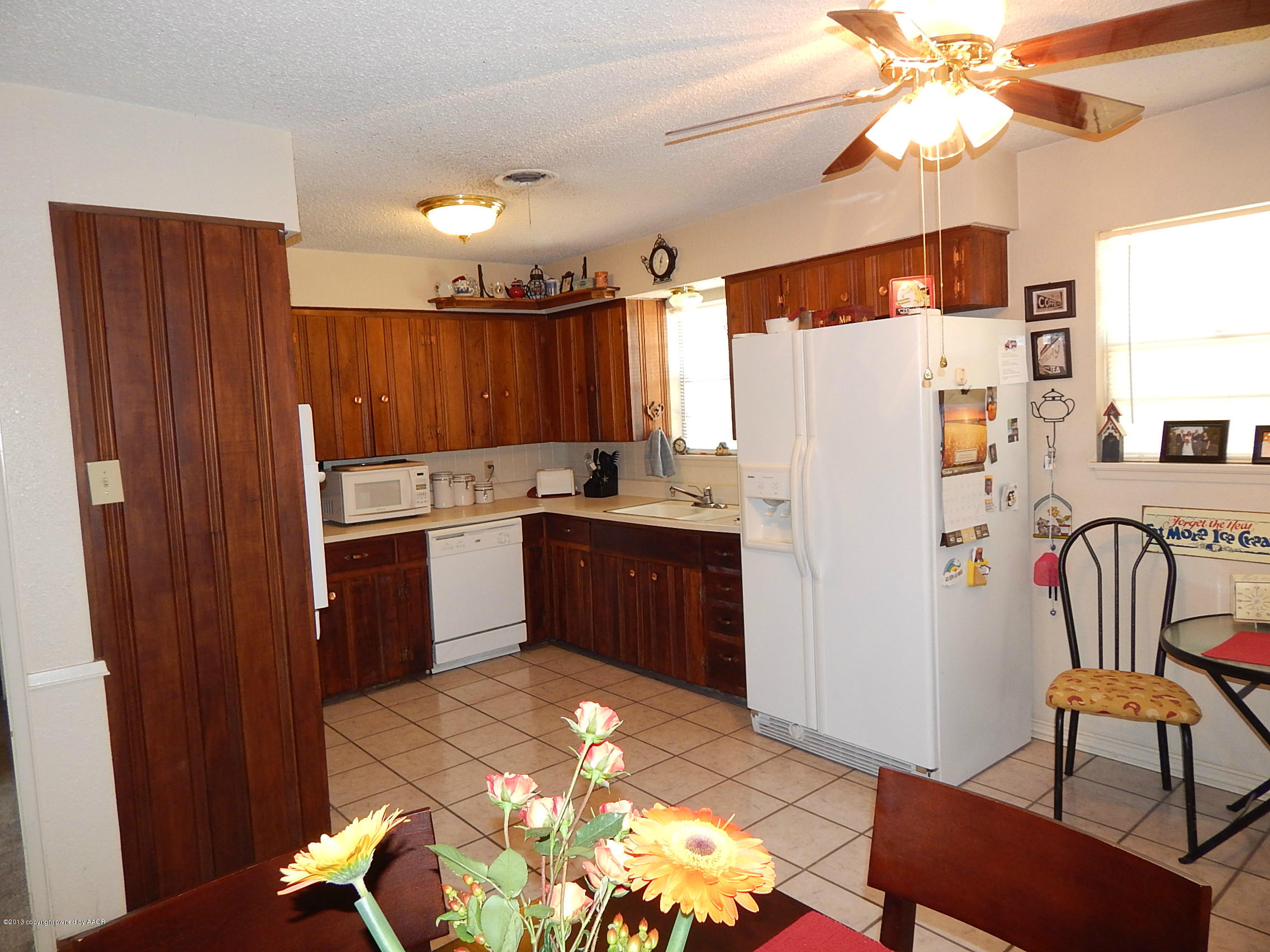 4700 South Milam Street Amarillo, TX 79110 - Photo 7 of 17 a kitchen with granite countertop a refrigerator a sink dishwasher a dining table and chairs with wooden floor