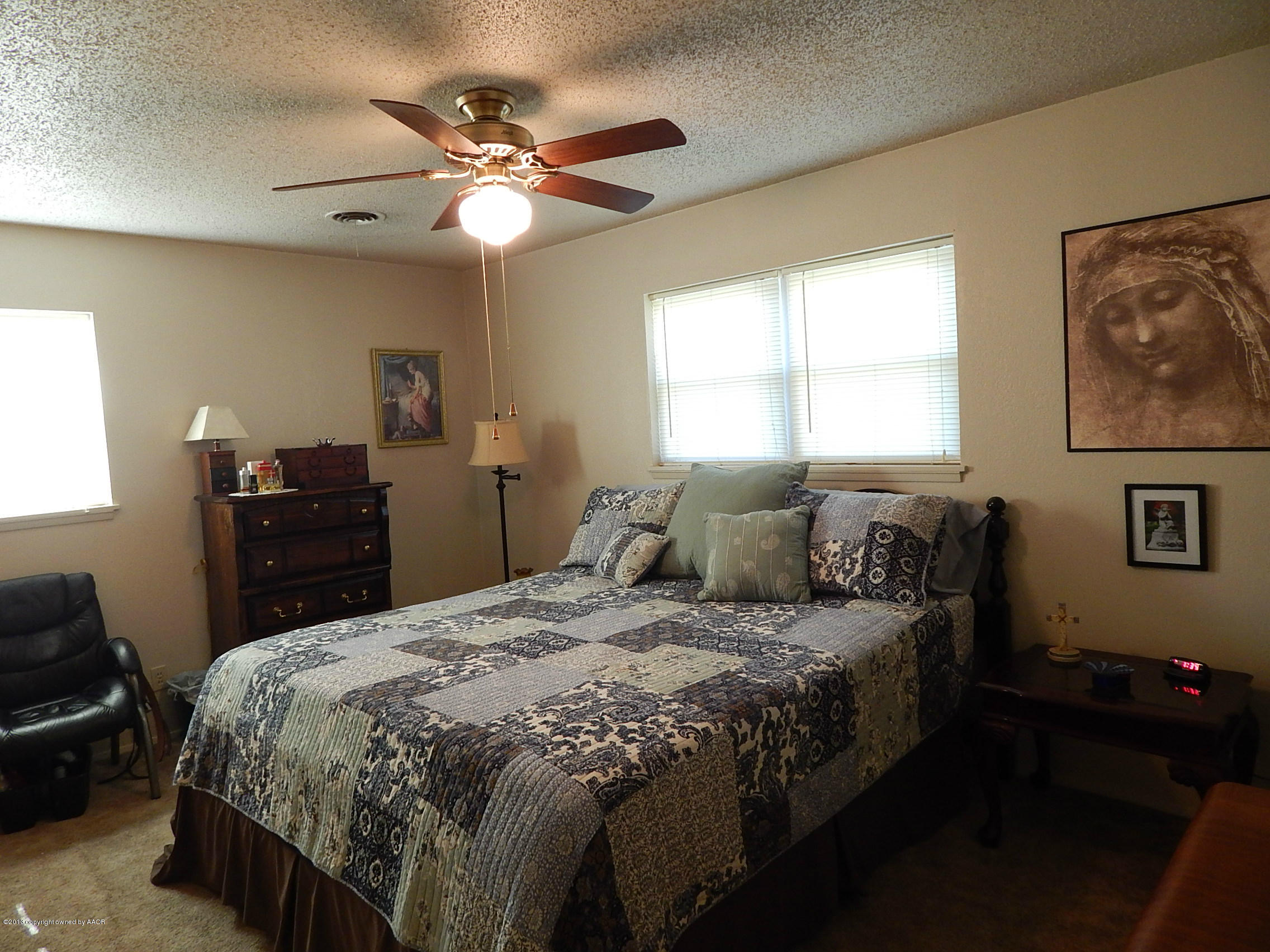 4700 South Milam Street Amarillo, TX 79110 - Photo 10 of 17 a bedroom with a bed and a chandelier
