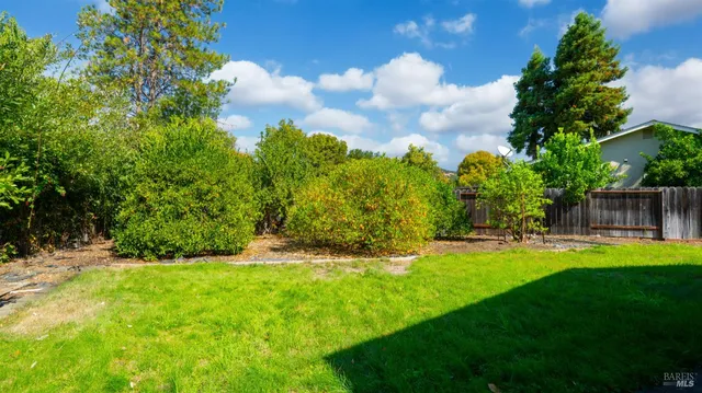 an aerial view of residential houses with outdoor space and trees