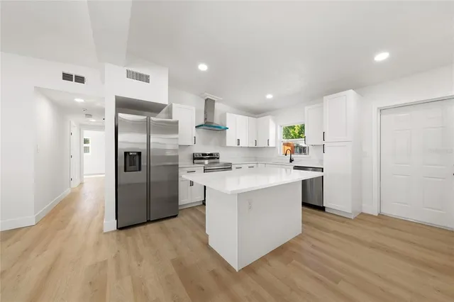 a kitchen with white cabinets and stainless steel appliances