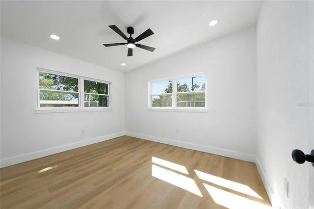 a view of a big room with wooden floor and windows