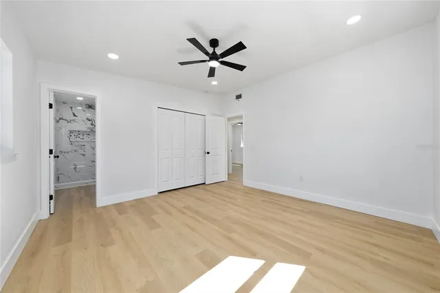 an empty room with closet and windows