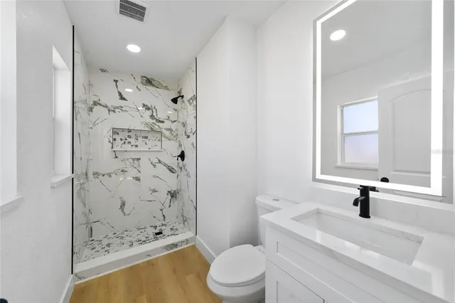 a bathroom with a sink toilet and shower