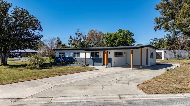 a front view of a house with a yard and trees
