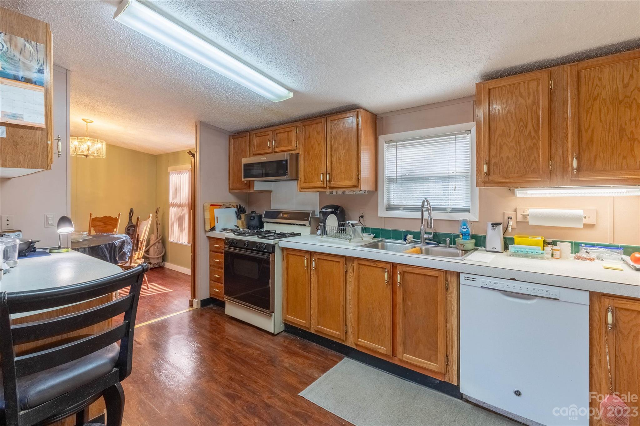 170 Painter Street Sylva, NC 28779 - Photo 11 of 48 a kitchen with stainless steel appliances a sink a stove a refrigerator cabinets and a window