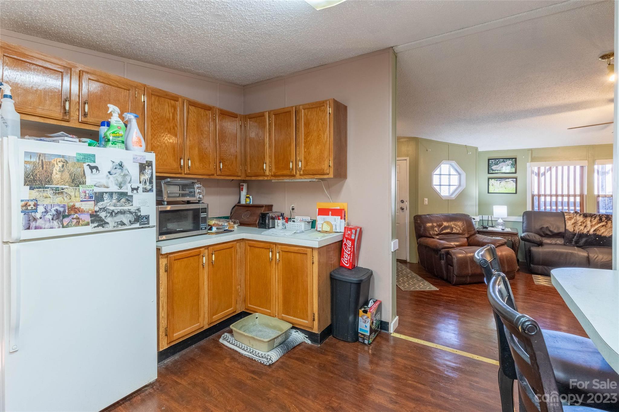 170 Painter Street Sylva, NC 28779 - Photo 8 of 48 a kitchen with stainless steel appliances granite countertop a refrigerator a sink dishwasher a stove and a dining table with wooden floor