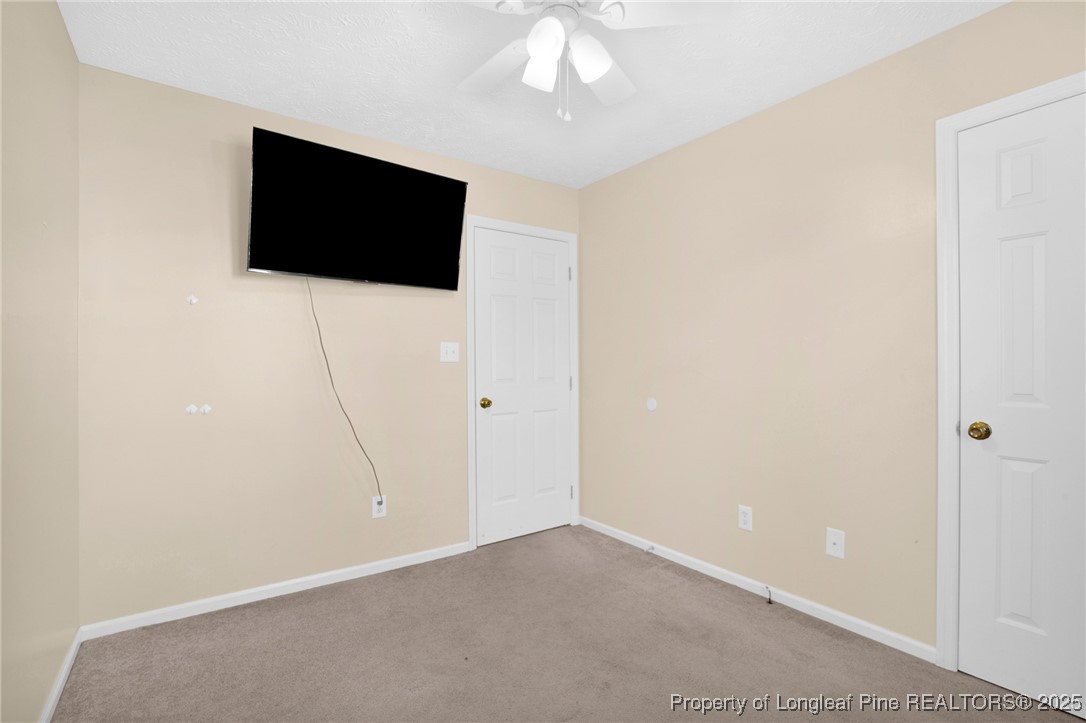 101 2 Hours Court Raeford, NC 28376 - Photo 17 of 30 a view of an empty room with a flat screen tv and a ceiling fan