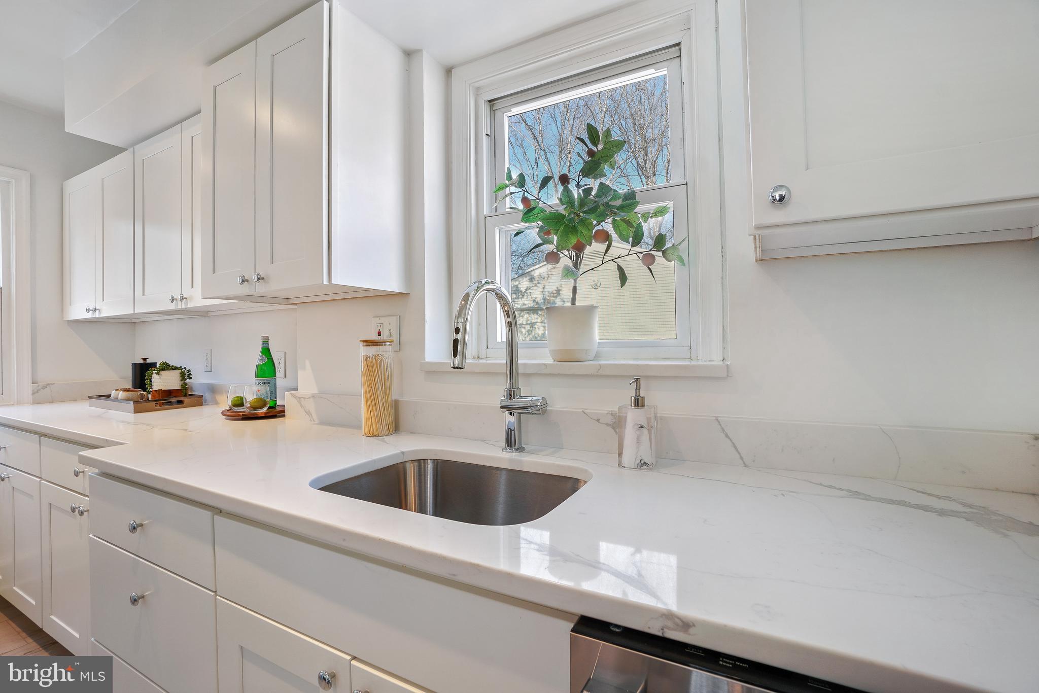 2707 Harmon Road Silver Spring, MD 20902 - Photo 9 of 22 a kitchen with stainless steel appliances white cabinets a stove a sink and a window