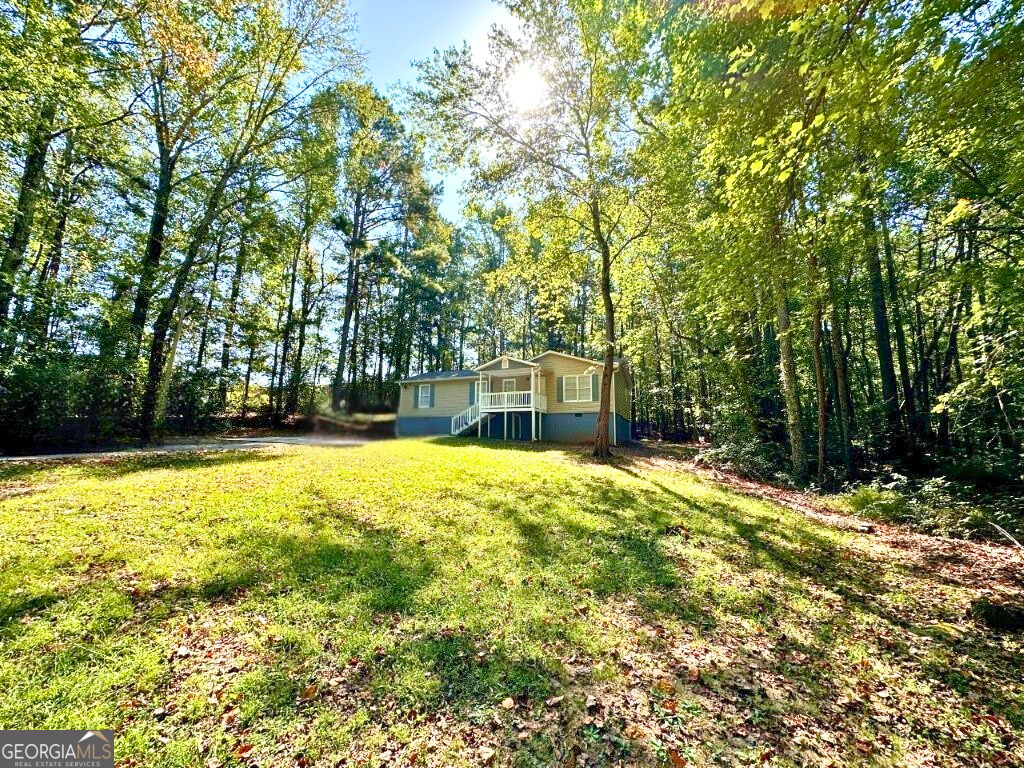 766 Country Club Road Newnan, GA 30263 - Photo 1 of 1 a view of a swimming pool with lawn chairs and large trees