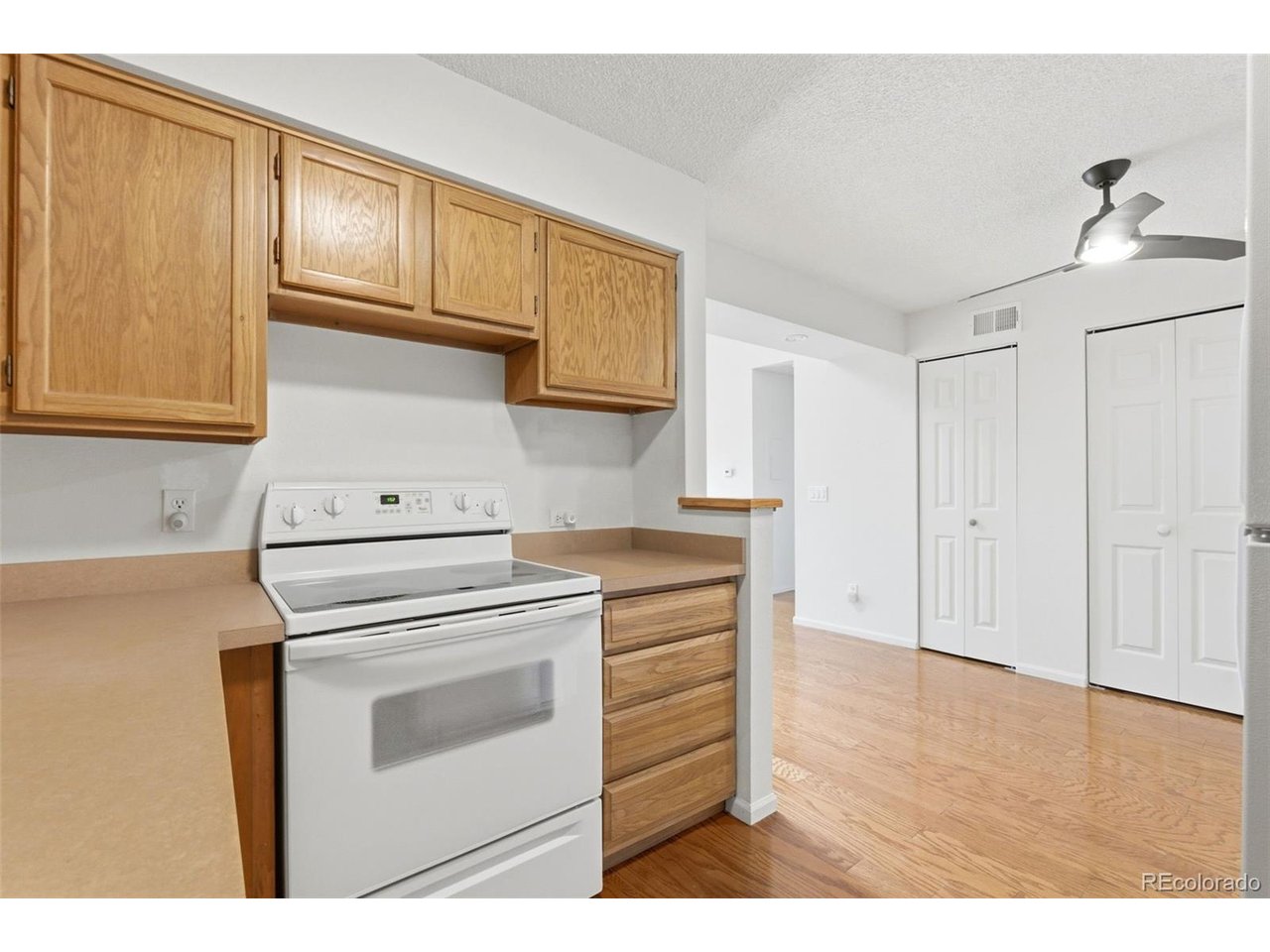 10251 West 44th Avenue, Unit 208 Wheat Ridge, CO 80033 - Photo 11 of 28 a kitchen with a stove cabinets and wooden floor