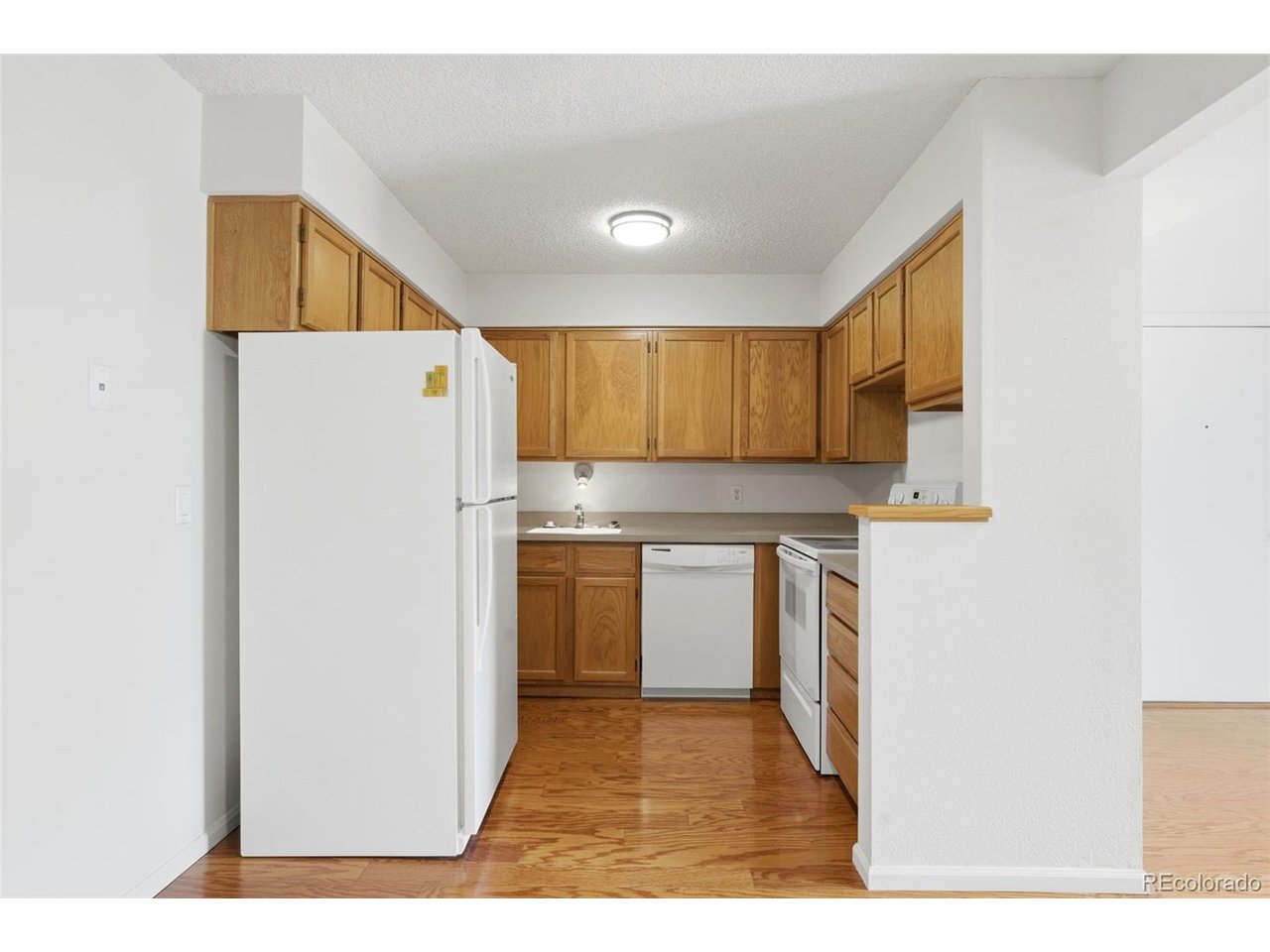 10251 West 44th Avenue, Unit 208 Wheat Ridge, CO 80033 - Photo 8 of 28 a kitchen with a refrigerator sink and cabinets