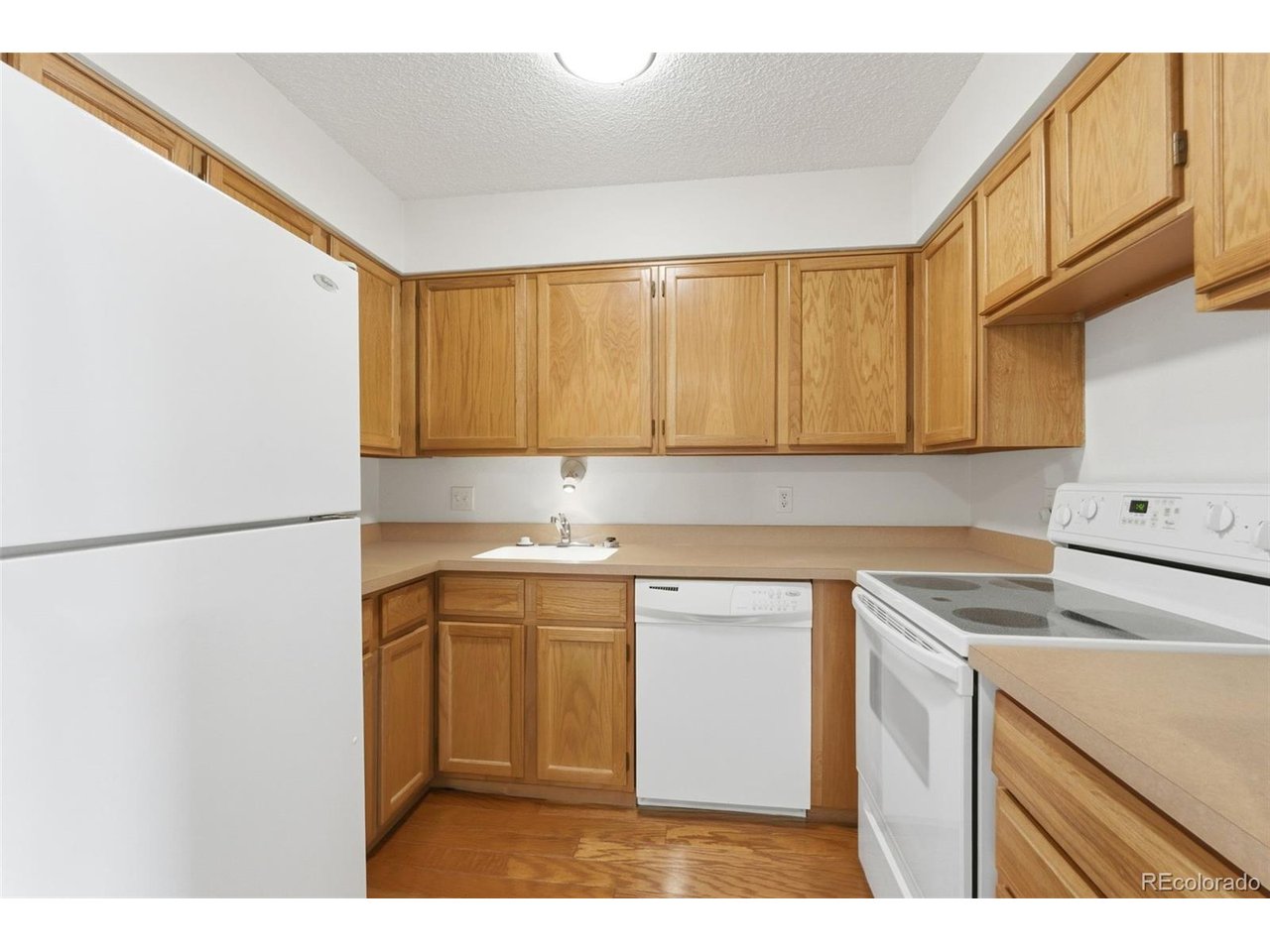 10251 West 44th Avenue, Unit 208 Wheat Ridge, CO 80033 - Photo 10 of 28 a kitchen with a sink a stove and cabinets