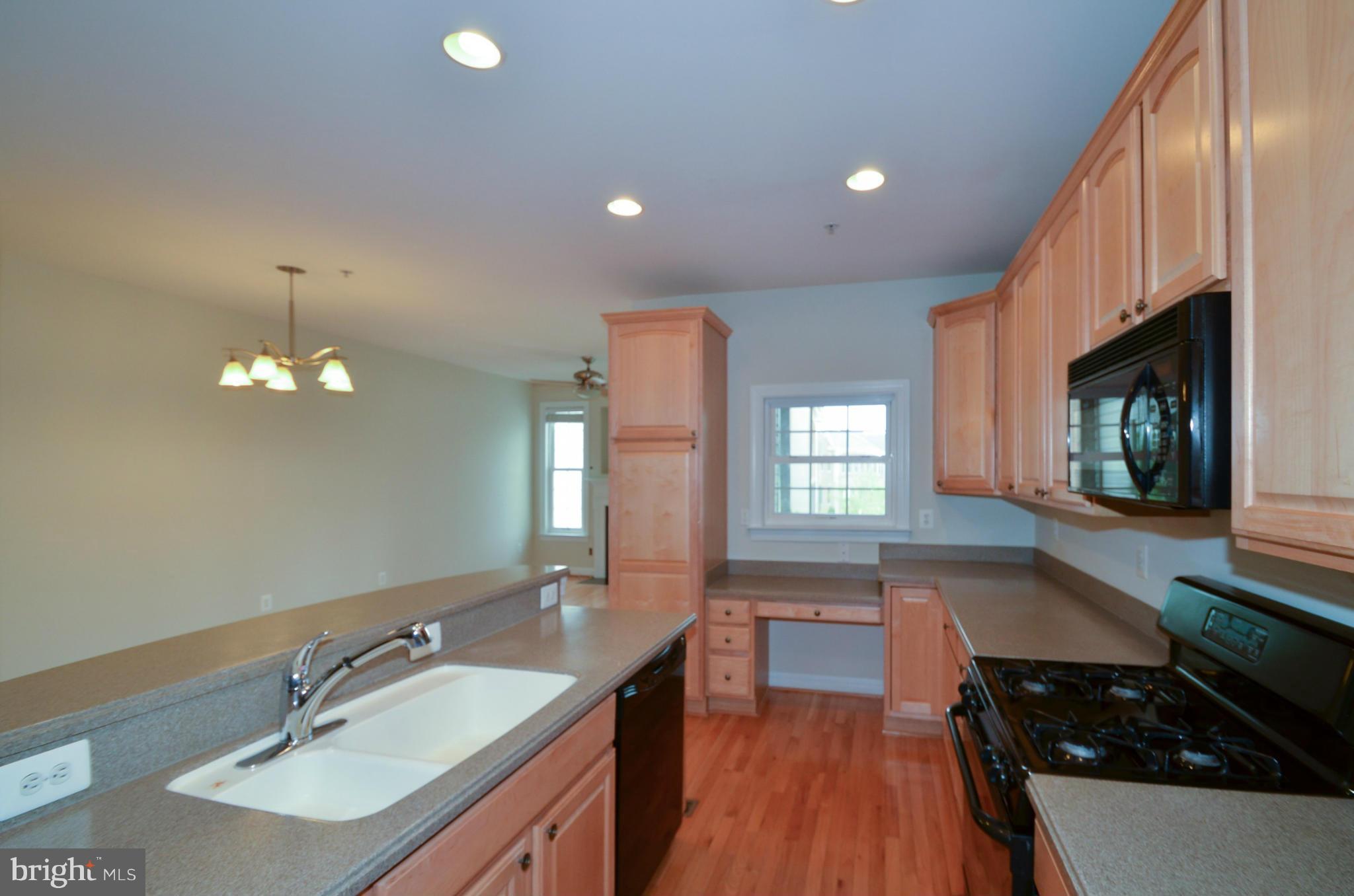 8306 Merlot Lane, Unit 137 Laurel, MD 20723 - Photo 11 of 30 a kitchen with stainless steel appliances a sink stove and cabinets
