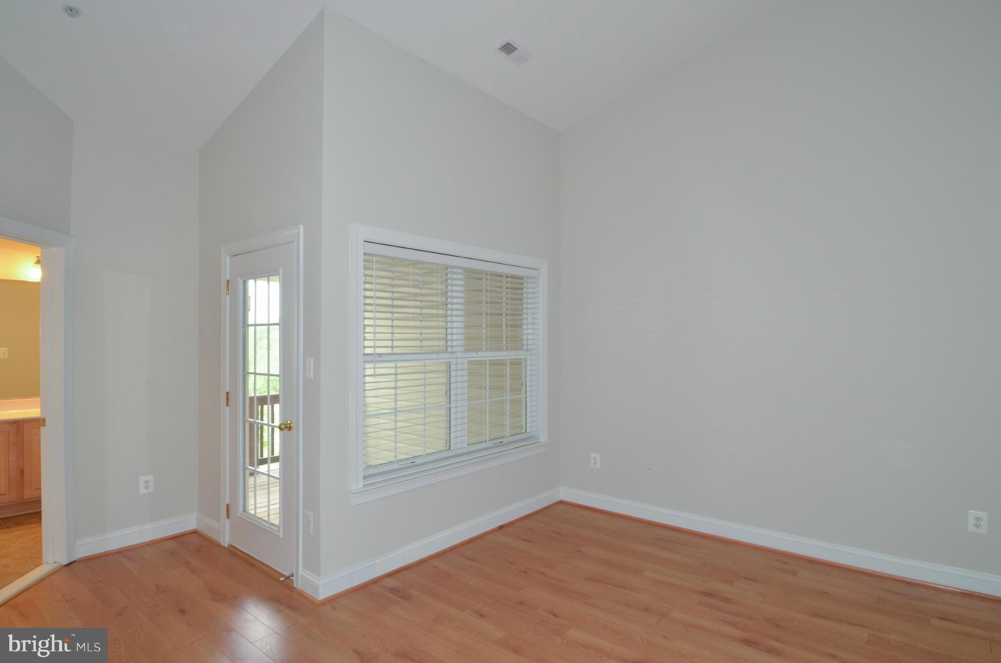 8306 Merlot Lane, Unit 137 Laurel, MD 20723 - Photo 14 of 30 an empty room with wooden floor and windows