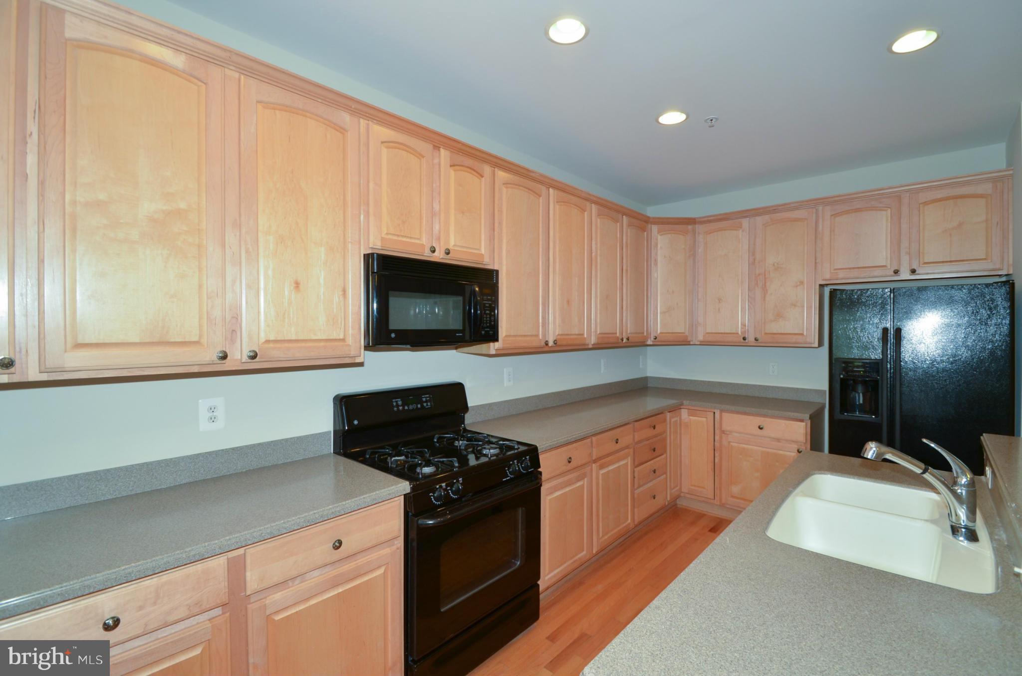 8306 Merlot Lane, Unit 137 Laurel, MD 20723 - Photo 8 of 30 a kitchen with stainless steel appliances granite countertop a sink a stove and a microwave