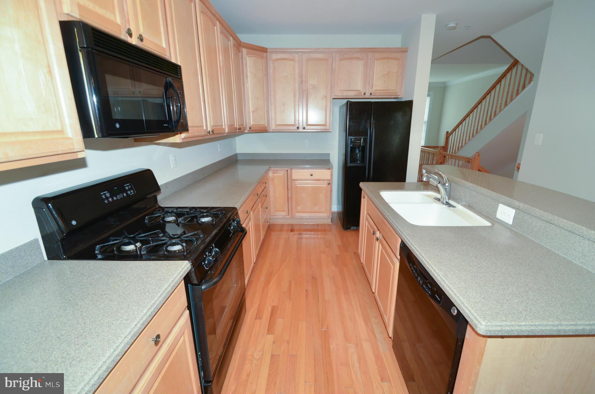 8306 Merlot Lane, Unit 137 Laurel, MD 20723 - Photo 9 of 30 a kitchen with a sink a stove and a microwave
