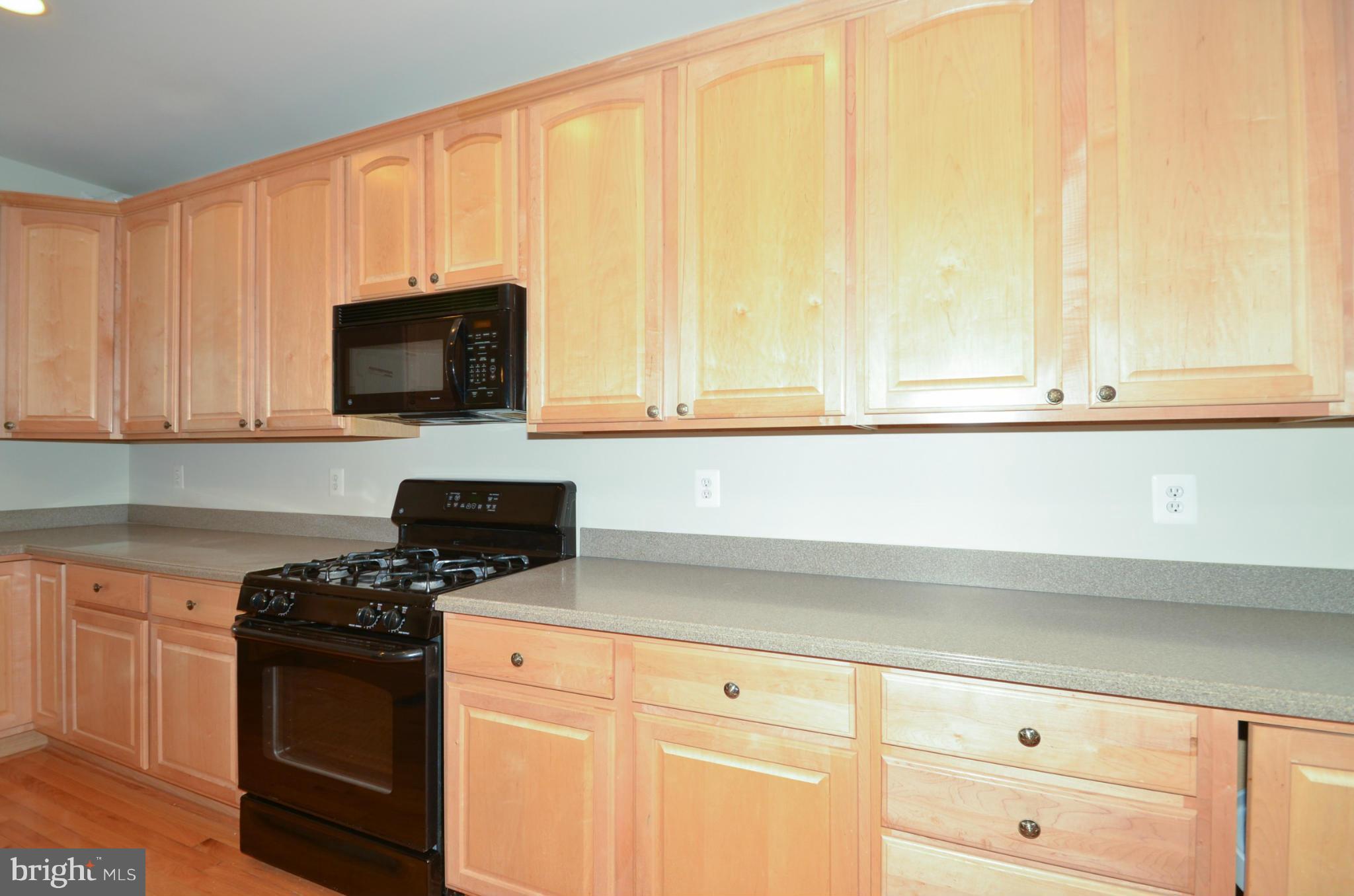 8306 Merlot Lane, Unit 137 Laurel, MD 20723 - Photo 10 of 30 a kitchen with stainless steel appliances a stove a microwave and cabinets