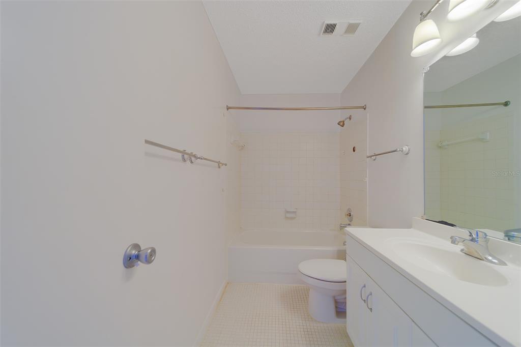 1 Windrush Boulevard, Unit 28 Indian Rocks Beach, FL 33785 - Photo 20 of 68 a bathroom with a granite countertop sink a toilet and shower
