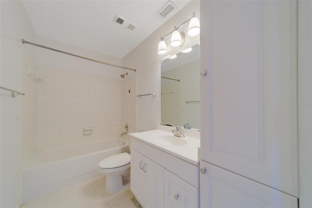 1 Windrush Boulevard, Unit 28 Indian Rocks Beach, FL 33785 - Photo 21 of 68 a bathroom with a granite countertop sink a toilet and shower