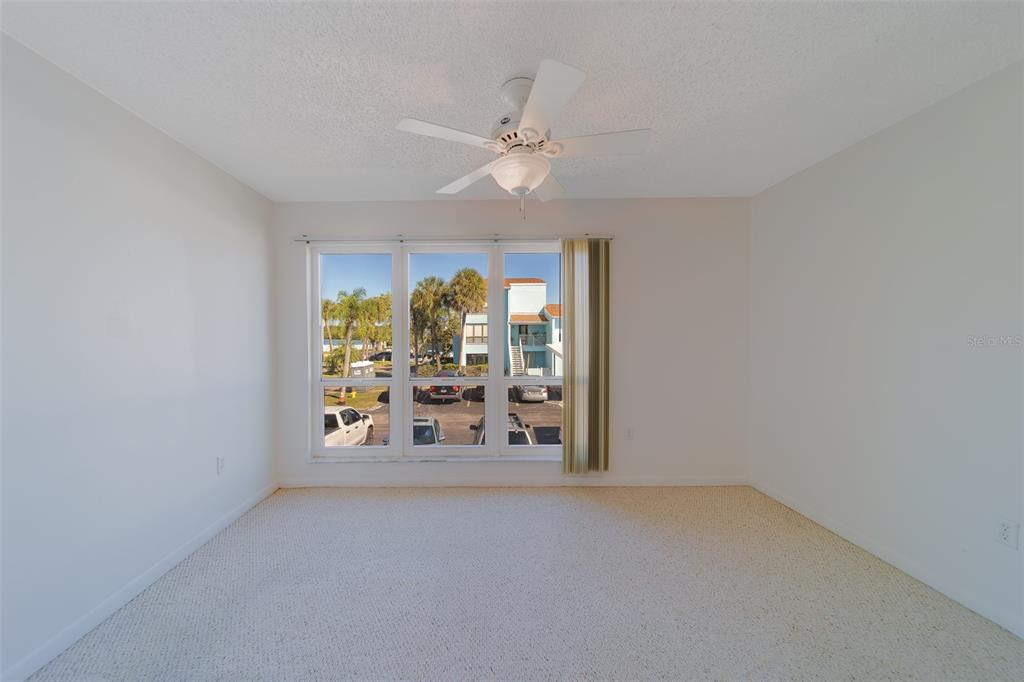 1 Windrush Boulevard, Unit 28 Indian Rocks Beach, FL 33785 - Photo 33 of 68 an empty room with window and chandelier fan