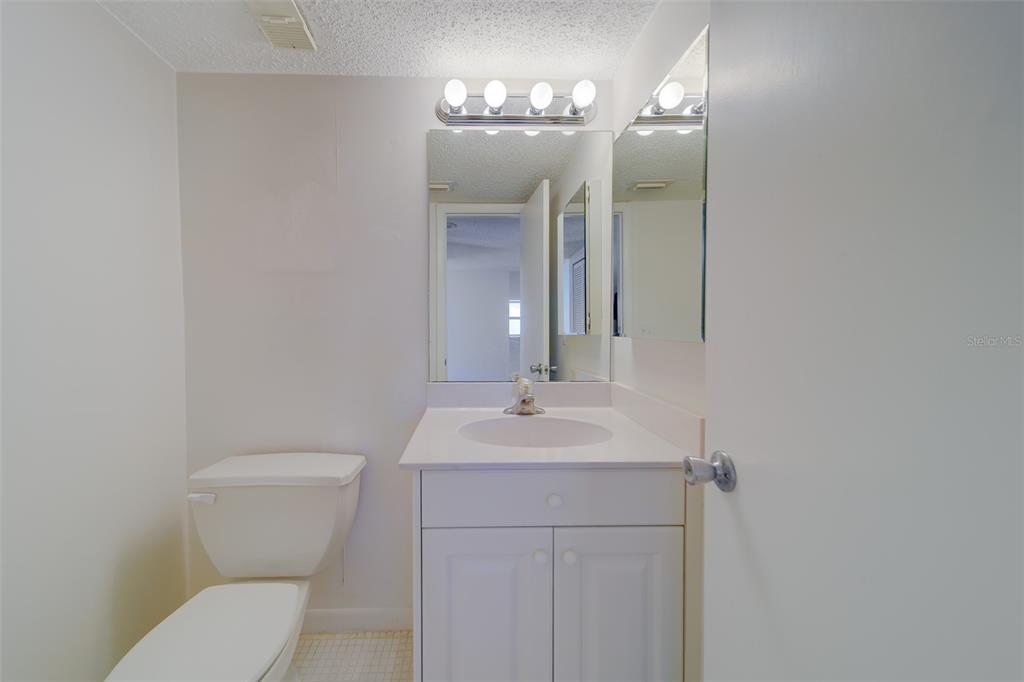 1 Windrush Boulevard, Unit 28 Indian Rocks Beach, FL 33785 - Photo 34 of 68 a bathroom with a toilet a sink and mirror