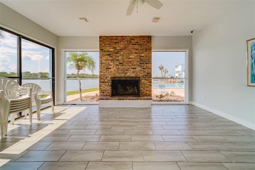 1 Windrush Boulevard, Unit 28 Indian Rocks Beach, FL 33785 - Photo 48 of 68 wooden floor fireplace and windows in an empty room