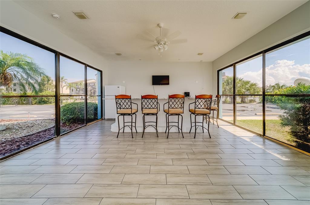 1 Windrush Boulevard, Unit 28 Indian Rocks Beach, FL 33785 - Photo 49 of 68 a view of a dining room with furniture large windows and wooden floor
