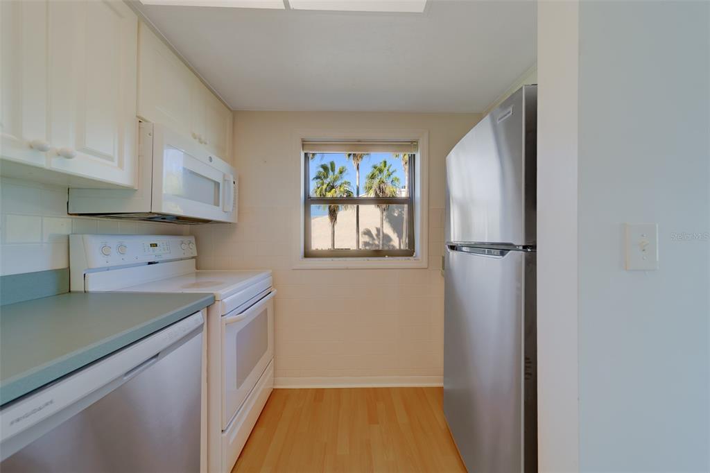1 Windrush Boulevard, Unit 28 Indian Rocks Beach, FL 33785 - Photo 5 of 68 a kitchen with a refrigerator and a sink