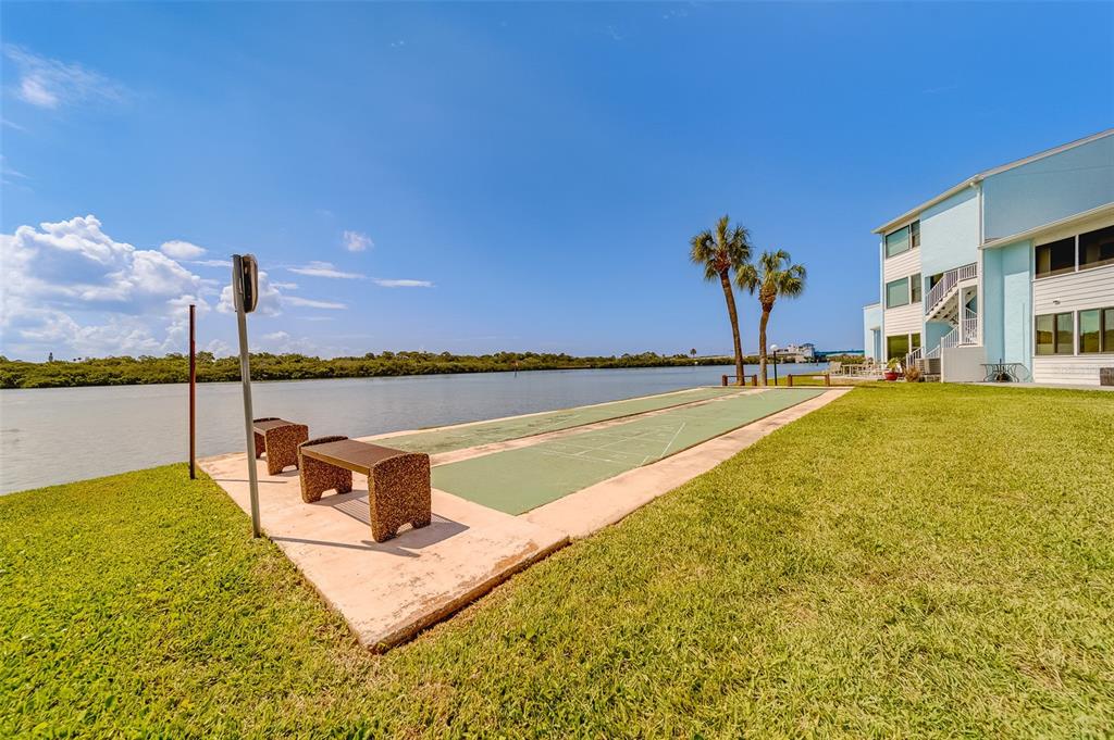 1 Windrush Boulevard, Unit 28 Indian Rocks Beach, FL 33785 - Photo 59 of 68 a view of a swimming pool with a table and chairs