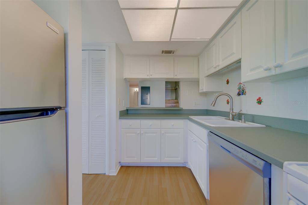 1 Windrush Boulevard, Unit 28 Indian Rocks Beach, FL 33785 - Photo 6 of 68 a kitchen with a sink cabinets and wooden floor