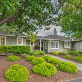 a front view of a house with a yard and potted plants