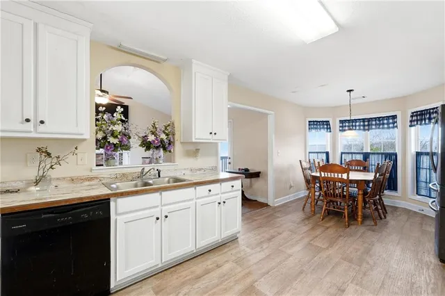 a kitchen with a dining table chairs sink and cabinets