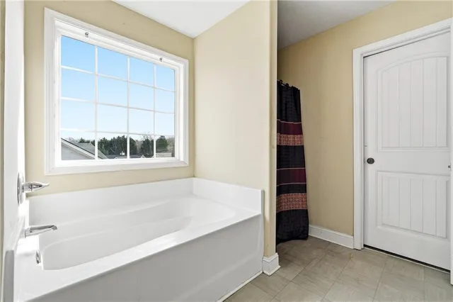 a bathroom with bathtub and a window