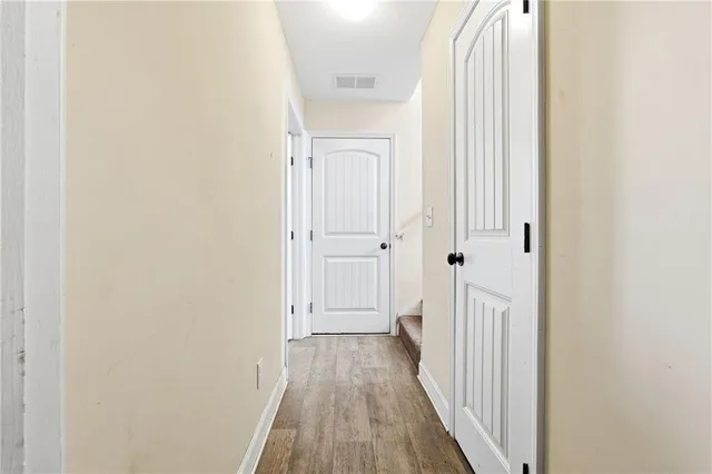 a view of a hallway with wooden floor and entryway