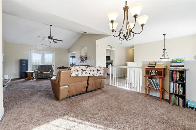 a living room with furniture kitchen view and a chandelier