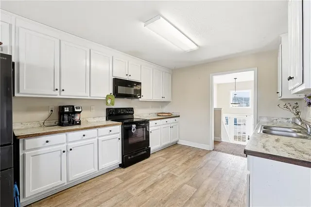 a kitchen with granite countertop white cabinets and white appliances