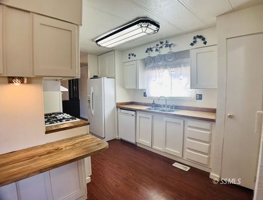 1370 Alpine Way Ridgecrest, CA 93555 - Photo 28 of 31 a kitchen with granite countertop white cabinets and white appliances