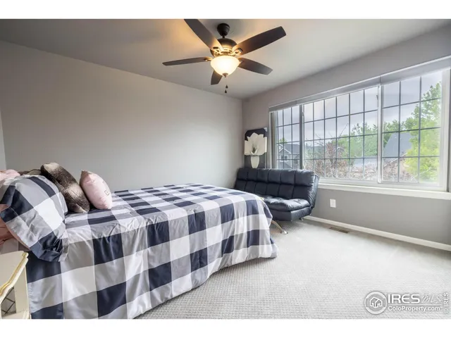 a bedroom with a bed and a large window