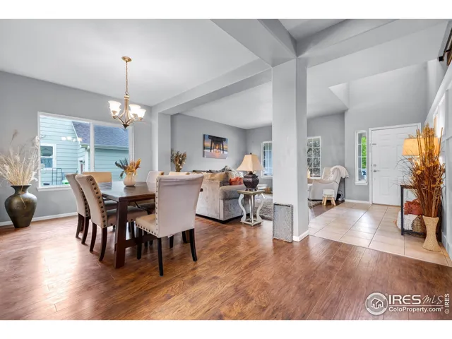 a view of a dining room and livingroom with furniture wooden floor a chandelier