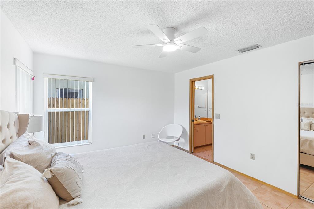 4537 South Lockwood Ridge Road Sarasota, FL 34231 - Photo 11 of 22 a bedroom with a bed and a chandelier