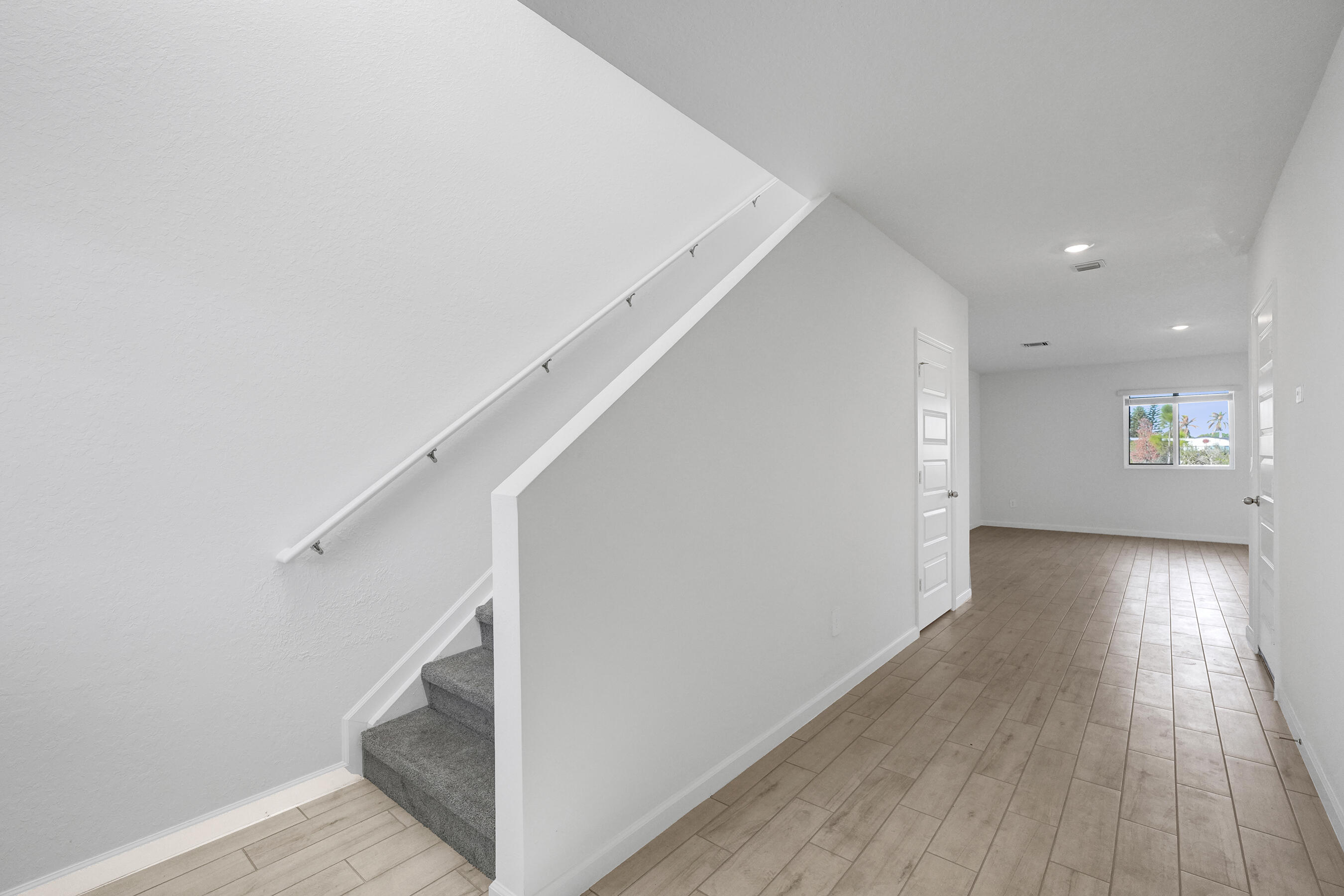 14308 Southwest New Dawn Road Indiantown, FL 34956 - Photo 4 of 25 a view of hallway with stairs and wooden floor