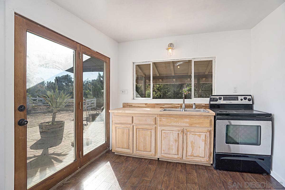 2756 Mission Road Fallbrook, CA 92028 - Photo 15 of 39 a kitchen with a stove and a wooden floor