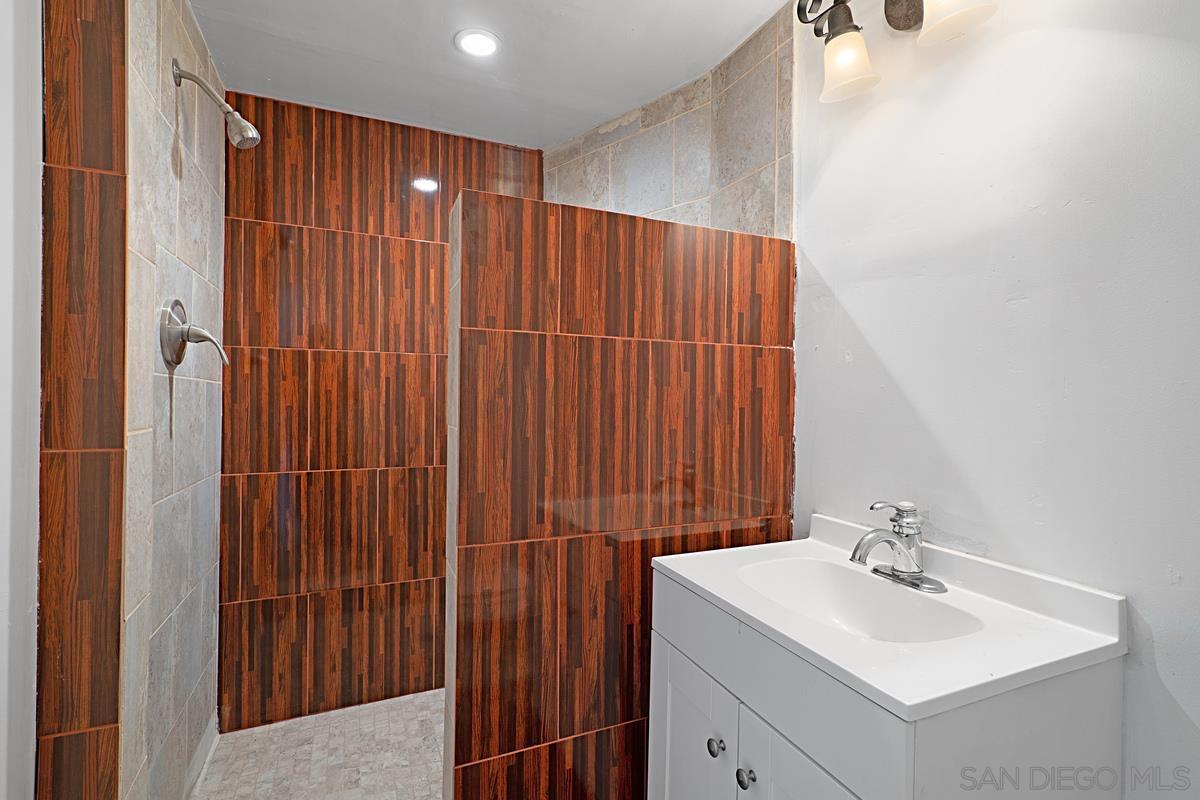 2756 Mission Road Fallbrook, CA 92028 - Photo 22 of 39 a bathroom with a sink a mirror and a shower curtain