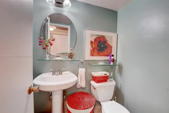 a bathroom with a toilet sink and mirror